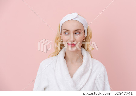 Pretty woman with blond hair, wearing white bathrobe, smiling model with light 92847741