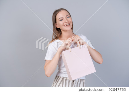 Young cheerful woman happy positive smile, hold bag package, buy customer sale 92847763