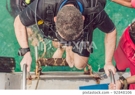 Happy diver returns to the ship after diving 92848106