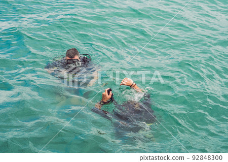 Divers on the surface of water ready to dive 92848300