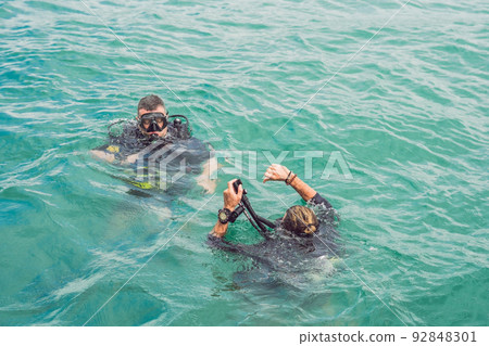 Divers on the surface of water ready to dive Divers on the surface of water ready to dive 92848301