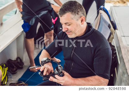 Diver prepares his equipment for diving in the sea 92848598
