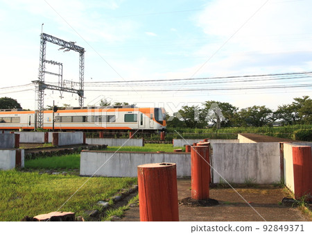 A train on the Kintetsu Nara Line that runs beside the restored ruins in the site of the world heritage Nara Heijo Palace 92849371