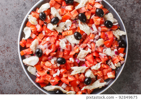 fresh and simple salad with cod and vegetables close-up in a plate. Horizontal top view 92849675