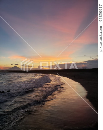 Mt. Fuji and the sunset seen from the shore of Nishihama, Chigasaki City in the twilight, afterglow on the beach [July] 92850917