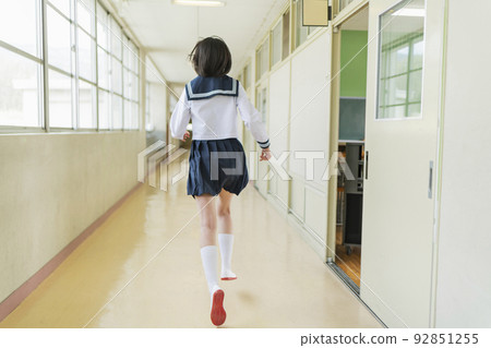 High school girl running in the school corridor 92851255