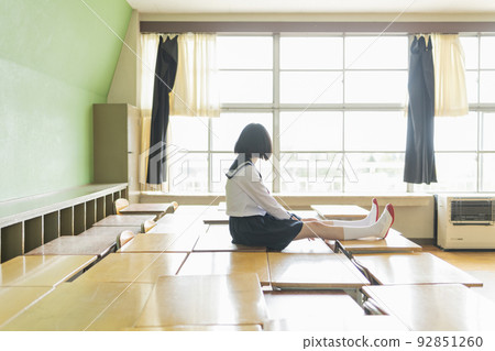 High school girl sitting on a classroom desk 92851260