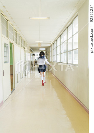High school girl running in the school corridor 92851284
