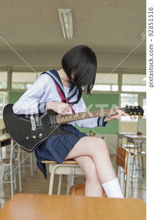 High school girl playing the guitar in the classroom 92851316