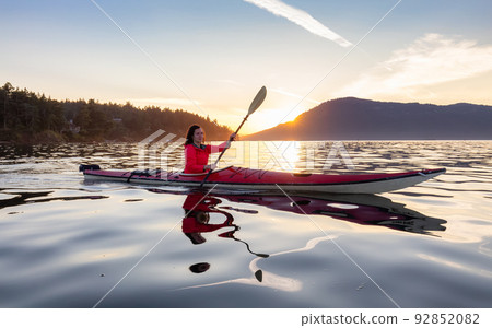 Adventurous Woman on Sea Kayak paddling in the Pacific Ocean. Adventurous Woman on Sea Kayak paddling in the Pacific Ocean. 92852082