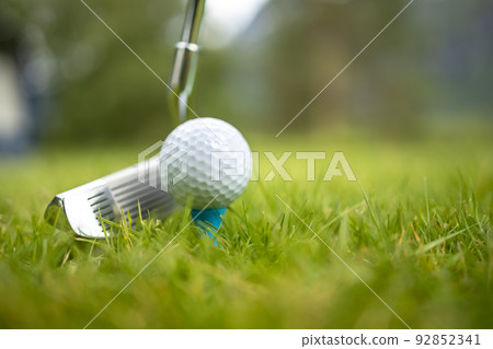 Golf ball on tee in front of driver Golf ball on tee in front of driver 92852341