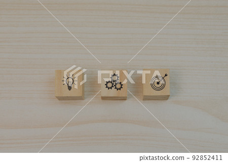 Strategy goals and investment plan business marketing icon symbol gear and light bulb with wood block cube on table. Strategy goals and investment plan business marketing icon symbol gear and light bulb with wood block cube on table. 92852411