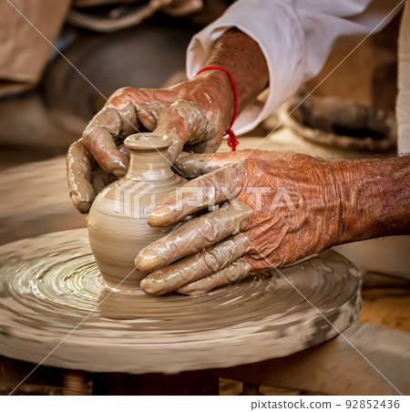 Potter at work makes ceramic dishes. India, Rajasthan. 92852436