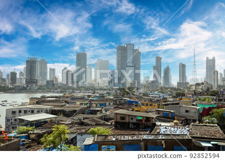 Views of slums on the shores of Mumbai, India against the backdrop of skyscrapers under construction. 92852594
