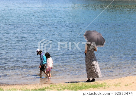 Parent and child playing in the summer sea 92853474