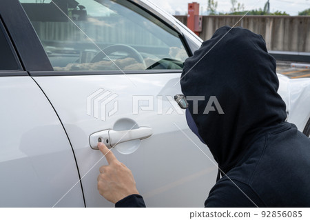Man checking car keyhole 92856085