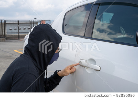 Man checking car keyhole 92856086