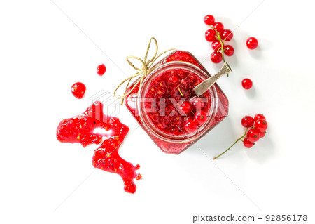 Homemade jam. Glass jar with red currant jam on white background. Preserved berry. Top view. Homemade jam. Glass jar with red currant jam on white background. Preserved berry. Top view. 92856178