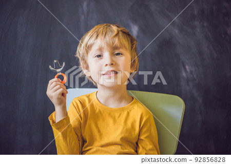 Three-year old boy shows vestibular plate. Plate with a bead to stimulate the tongue. dysarthria, rhinolalia 92856828