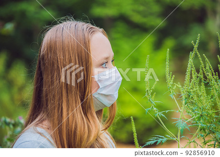 Young woman in a medical mask because of an allergy to ragweed 92856910