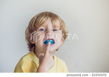 Three-year old boy shows myofunctional trainer to illuminate mouth breathing habit. Helps equalize the growing teeth and correct bite. Corrects the position of the tongue Three-year old boy shows myofunctional trainer to illuminate mouth breathing habit. Helps equalize the growing teeth and correct bite. Corrects the position of the tongue 92856939