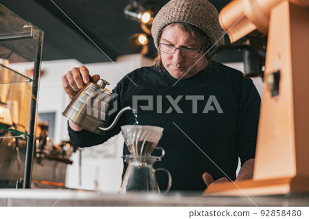 Hand drip coffee, Barista pouring water on coffee ground with filter Hand drip coffee, Barista pouring water on coffee ground with filter 92858480