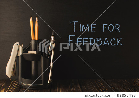 Text Time for Feedback and holder with stationery on table Text Time for Feedback and holder with stationery on table 92859483