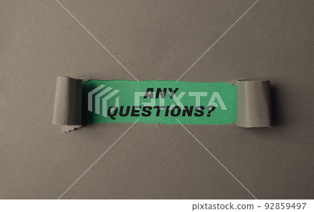 Text Any Questions on green view through torn paper 92859497