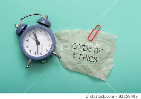 Text Code of Ethic and alarm clock on mint background Text Code of Ethic and alarm clock on mint background 92859499