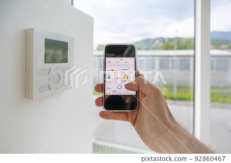 Hand hold an automation home app on mobile phone Hand hold an automation home app on mobile phone 92860467
