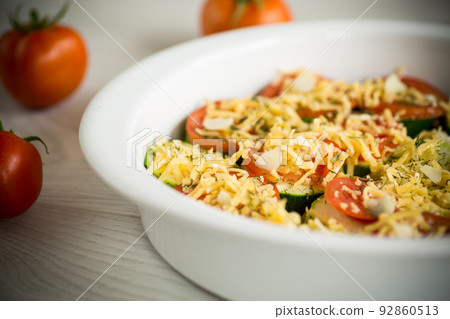 raw zucchini and tomatoes sliced with cheese, prepared for baking 92860513