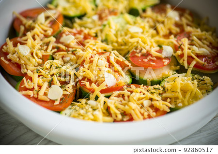 raw zucchini and tomatoes sliced with cheese, prepared for baking raw zucchini and tomatoes sliced with cheese, prepared for baking 92860517