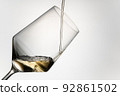 close-up of pouring white wine into a crystal glass. filling white wine into a crystal glass isolated on a grey background. image to cut out. beverage concept. 92861502
