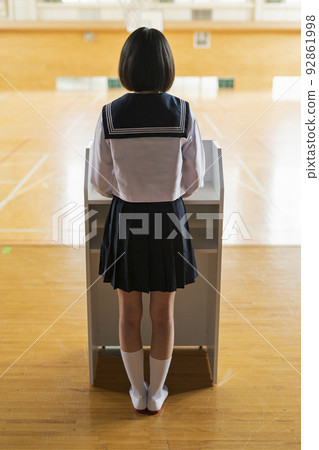 High school girl giving a speech on the gymnasium stage High school girl giving a speech on the gymnasium stage 92861998
