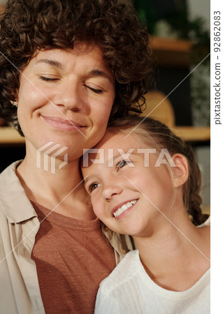 Young serene woman with her eyes closed and cute youthful girl with toothy smile 92862083