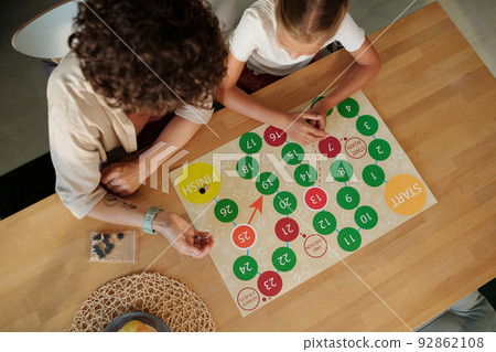 Above angle of young woman throwing dice over paper with circles Above angle of young woman throwing dice over paper with circles 92862108