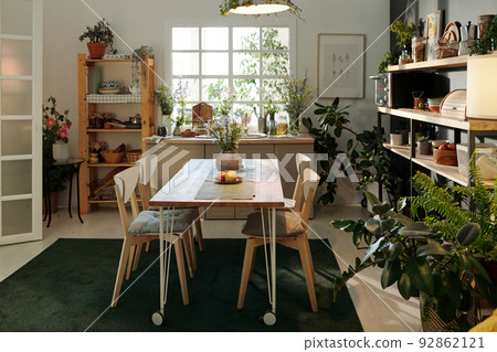 Interior of cozy kitchen in modern apartment with table and chairs on carpet 92862121