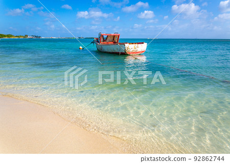 Idyllic beach with rustic wooden fishermen boat in Aruba, Dutch Antilles Idyllic beach with rustic wooden fishermen boat in Aruba, Dutch Antilles 92862744