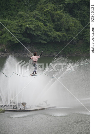 Slackline with the dam fountain in the background Slackline with the dam fountain in the background 92866121