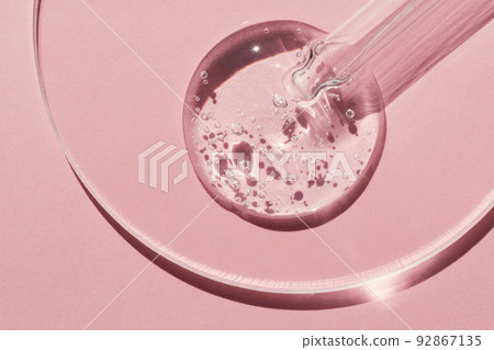 Pipette with sample of gels cosmetic product in petri dish on pink background, hard shadows 92867135