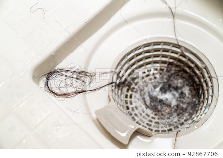 A photo of hair loss stuck in the drain of a bath. Image of trouble around water. Clogged water. 92867706