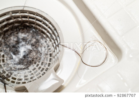A photo of hair loss stuck in the drain of a bath. Image of trouble around water. Clogged water. 92867707