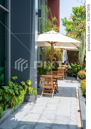 Outdoor seat with parasols at hotel balcony with plant decor Outdoor seat with parasols at hotel balcony with plant decor 92867809