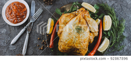 Roasted turkey or chicken. The Christmas table is served with a turkey decorated with bright tinsel. Fried chicken. table setting. Christmas dinner. Photo banner. top view on wooden background Roasted turkey or chicken. The Christmas table is served with a turkey decorated with bright tinsel. Fried chicken. table setting. Christmas dinner. Photo banner. top view on wooden background 92867896