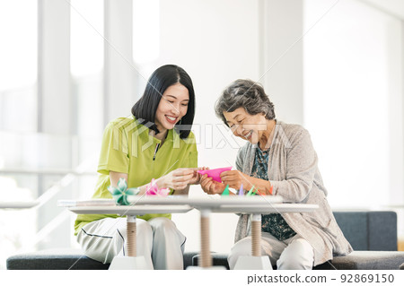 照顧者和資深婦女折疊摺紙 92869150