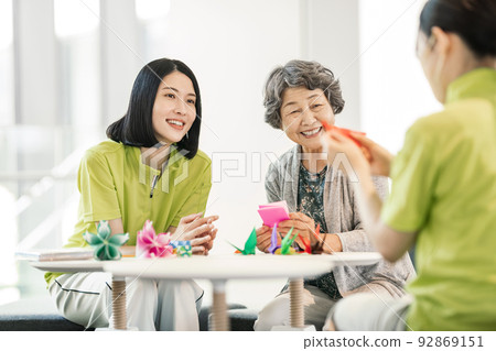 照顧者和資深婦女折疊摺紙 92869151