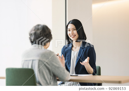A woman explaining to a senior woman 92869153