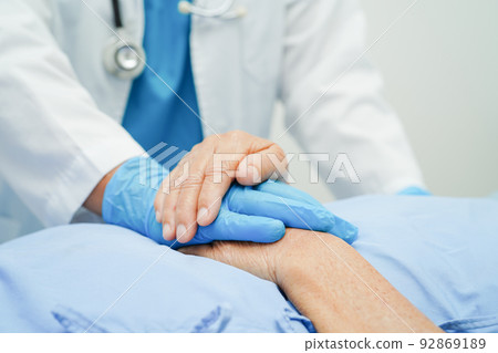Doctor holding hands Asian elderly woman patient, help and care in hospital. 92869189