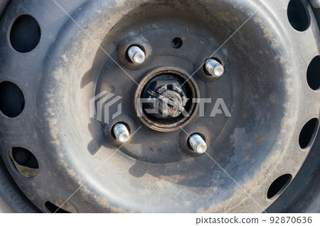 Bolts with unscrew nuts from a car wheel. Bolts with unscrew nuts from a car wheel. 92870636