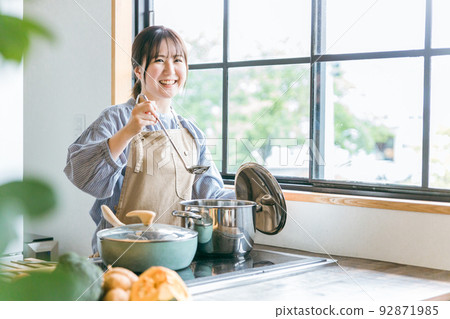 Asian woman cooking in the kitchen (curry stew) Asian woman cooking in the kitchen (curry stew) 92871985
